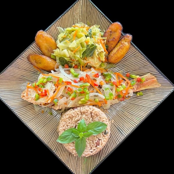 Whole fried fish topped with peppers and onions, served with rice, cabbage, and plantains.